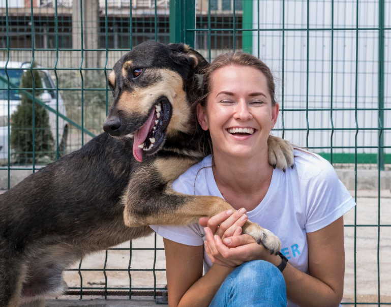 Happy rescue dog hugging woman, proving pet adoption myths wrong