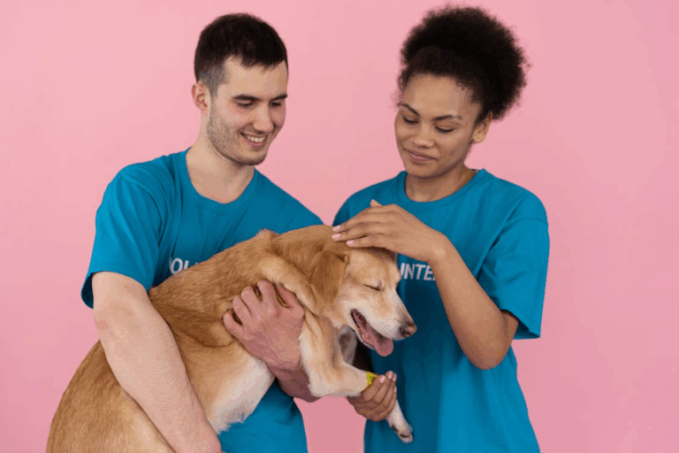 Animal shelter volunteers comforting a happy rescue dog.